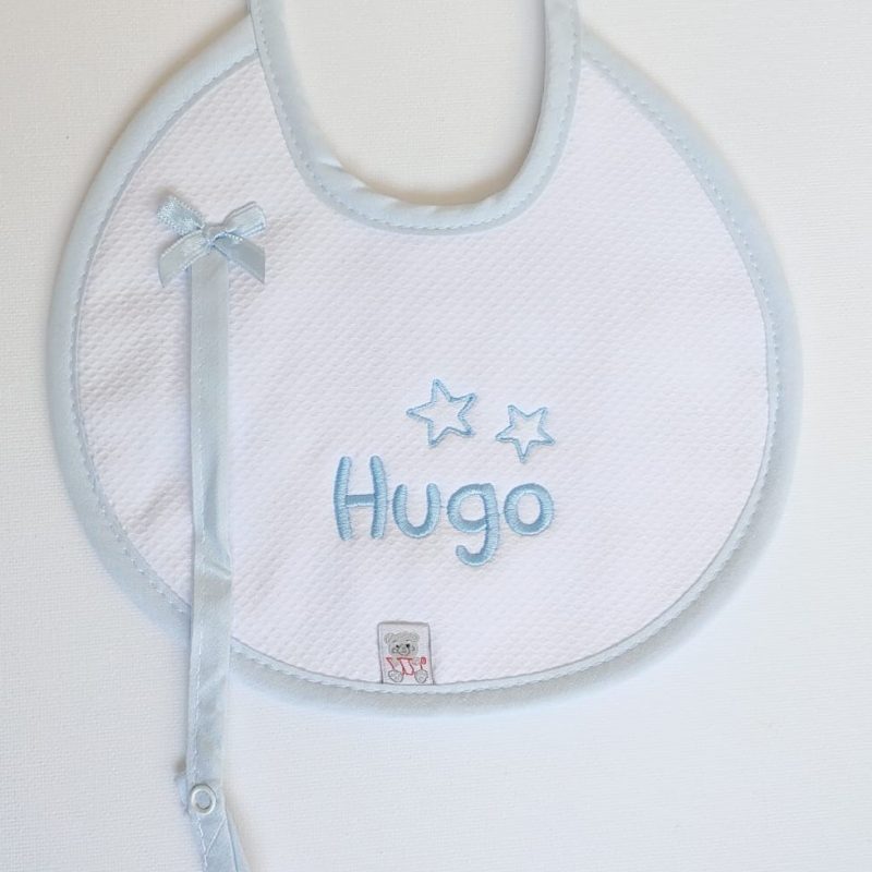 Babero redondo en piqué blanco ribeteado en azul con chupetero